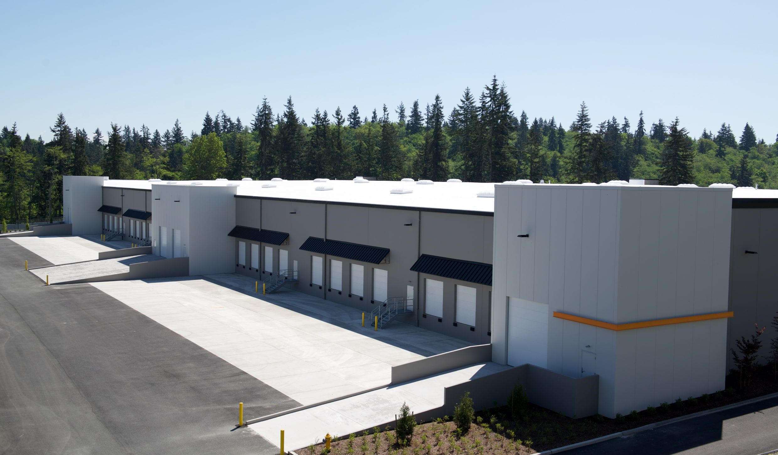 Aerial view of warehouse loading docks edged by forest