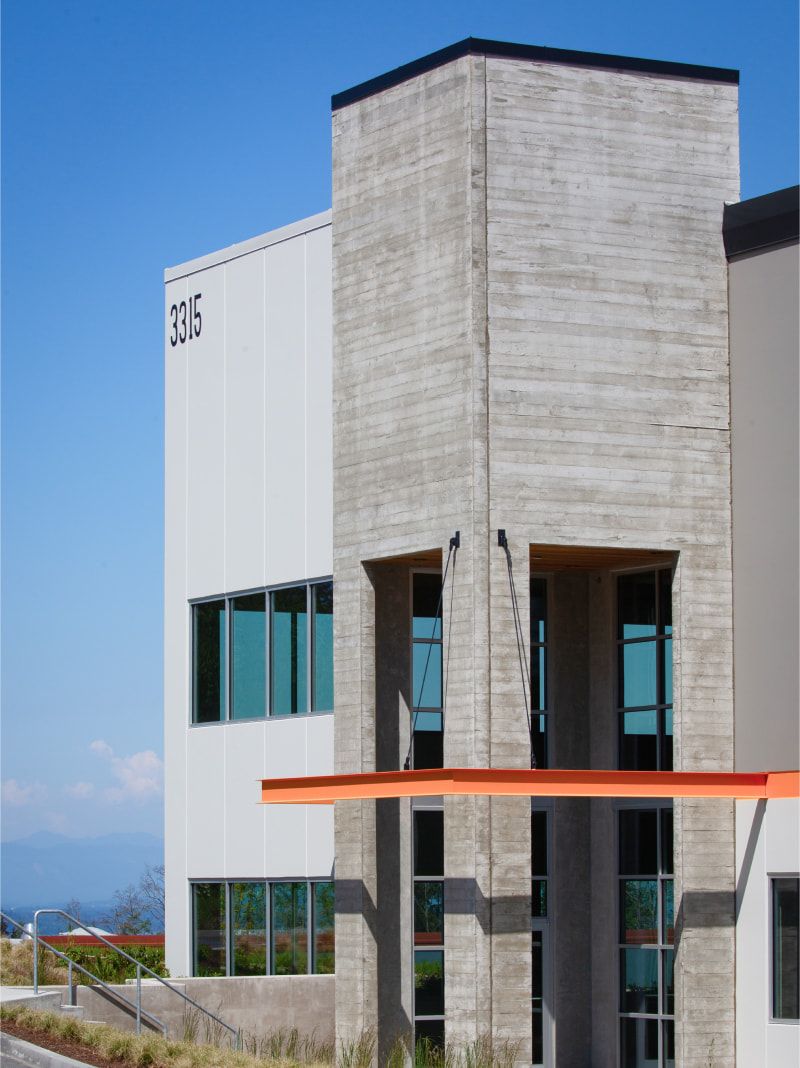 Board-formed concrete tower at Seaway West with an orange accent stripe