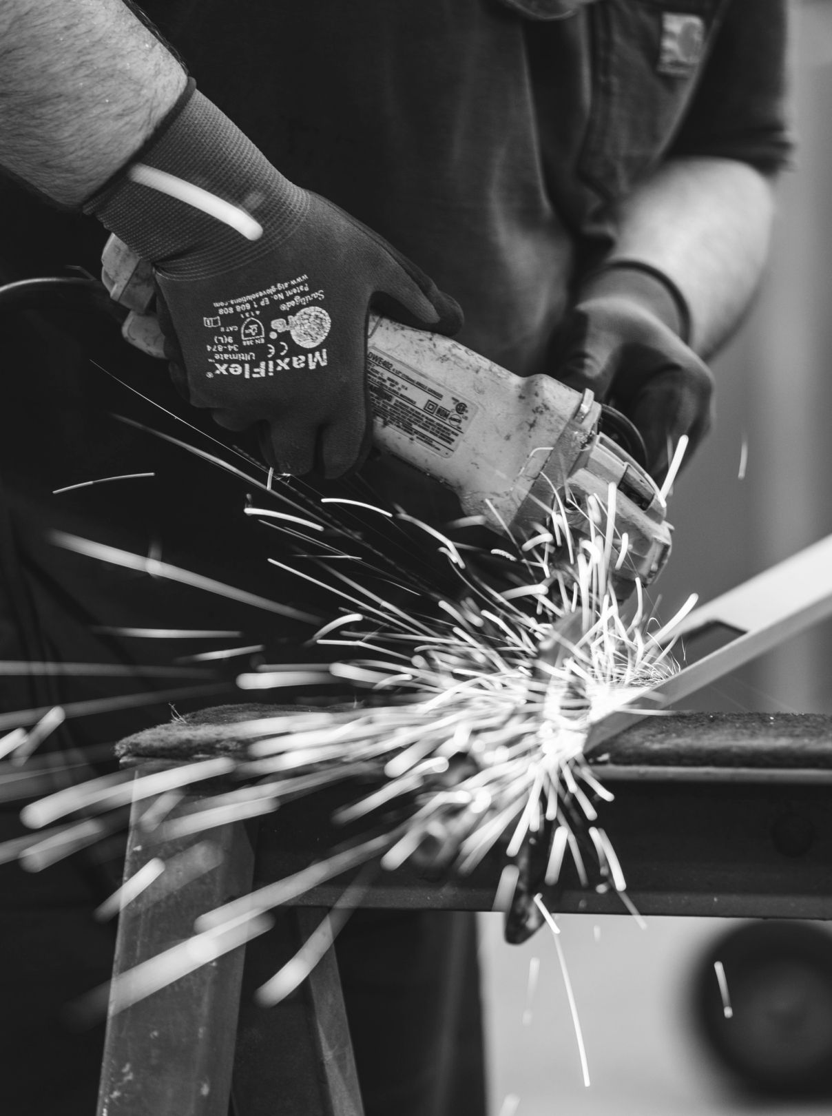 Worker grinding steel, sparks flying