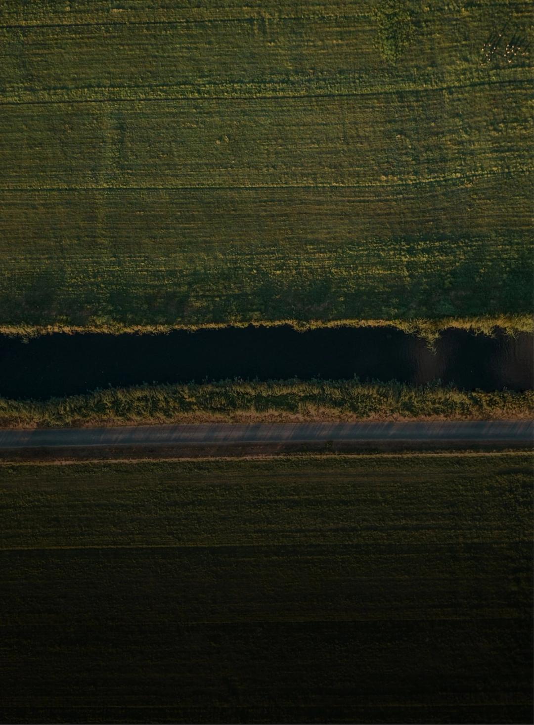 Aerial view of a river crossing farmland at dusk